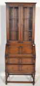 An early 20th Century oak geometric bureau bookcase, adjustable shelves behind glazed doors over