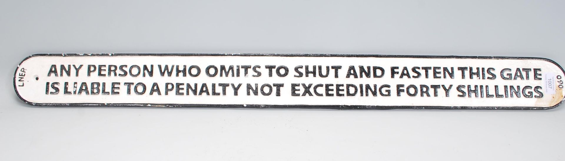 A 20th Century cast iron reproduction railway sign reading 'Any person who omits to shut and