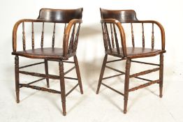 A pair of early 20th Century Edwardian spindle back smokers bow armchairs having shaped arm rest and