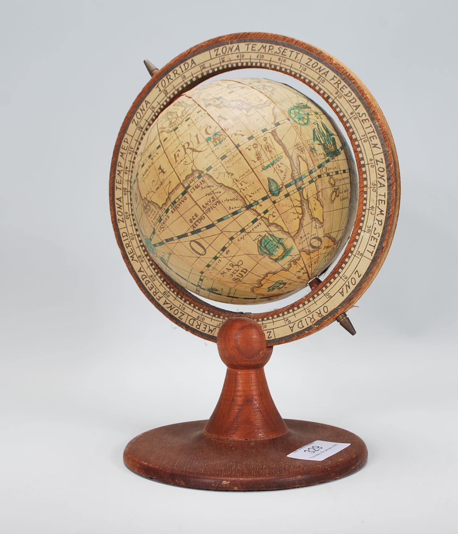 A antique style vintage desk top globe raised on a round wooden base with globe above set within a