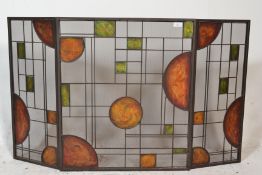 A 20th Century Art Nouveau style tri-fold fire screen of metal construction having green and orange,