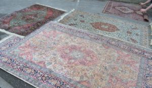 A group of three vintage floor rugs of varying sizes of similar designing having cream ground with