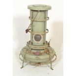 A vintage retro 20th Century metal paraffin heater by Aladdin of cylindrical form raised on a