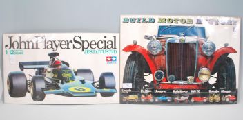 Two vintage toy store point of sale shop display cards to include; Tamiya 1:12 JPS John Players