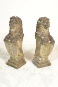 A pair of large reconstituted garden statues in the form form of armorial lions. Each lion raised