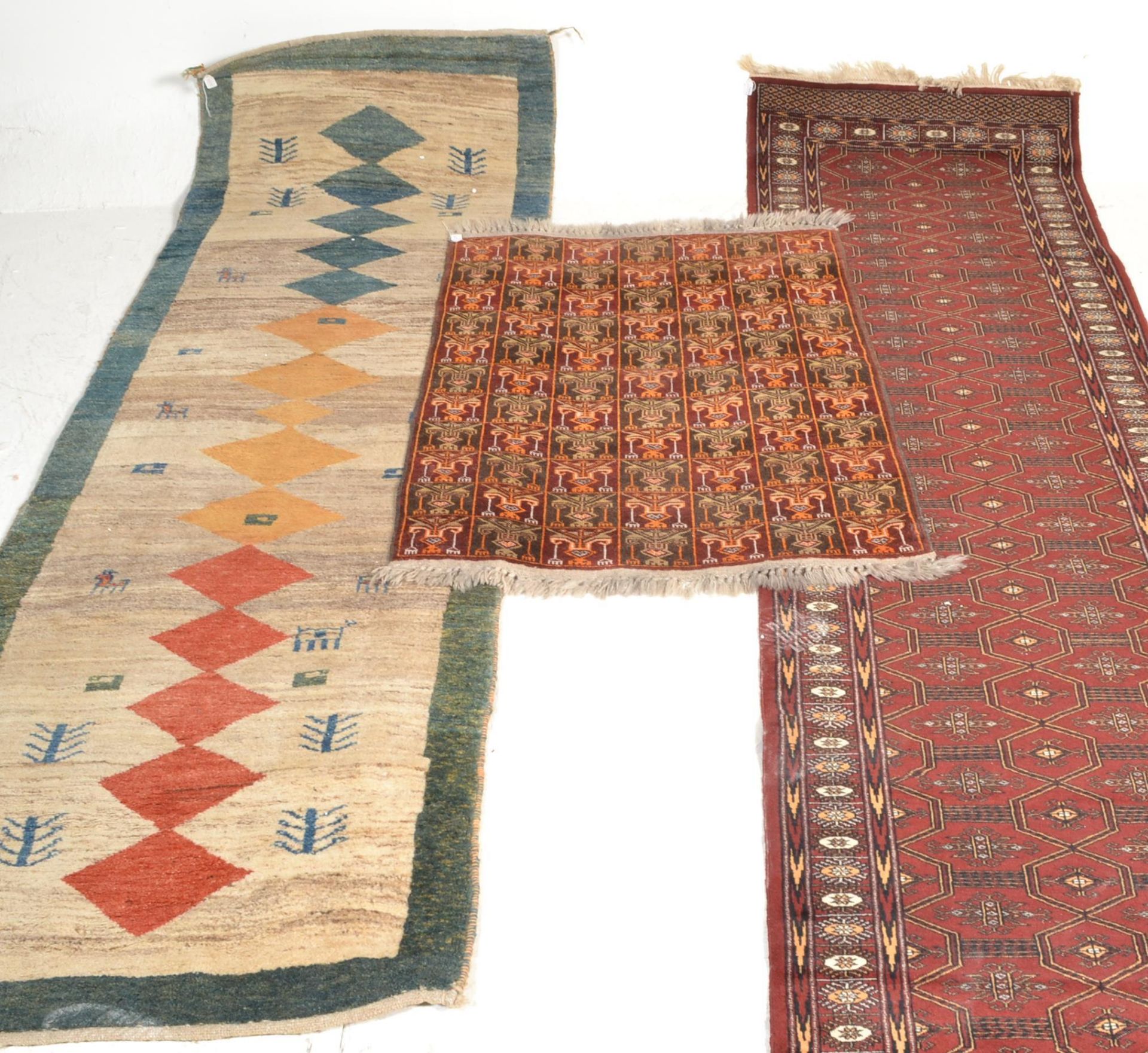A collection of  20th century rugs to include a large red ground Persian runner with geometric