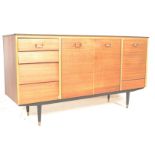 A retro mid century teak wood sideboard credenza being raised on turned legs with a wide body
