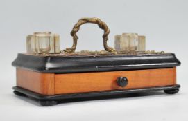 An early 20th Century walnut veneered desk top tide / inkwell having mounted brass floral and scroll