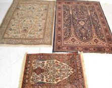 A collection of 3 Persian / Islamic rugs to include a beige ground rug with heavily decorated centre