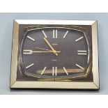 A retro 20th Century wall clock by Metamec, the square clock set within a gilt frame on brown