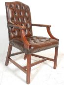 A 20th Century Antique style brown leather Gainsborough wing back armchair raised on straight