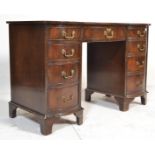 A reproduction 20th Century Georgian revival kneehole bow fronted twin pedestal writing desk with