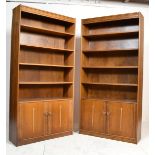 A pair of retro 1970's oak upright library bookcase cabinets. Rasied on plinth base with double door