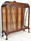 A 1930's Queen Anne revival mahogany china display cabinet being raised claw and ball feet with