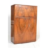 An Art Deco walnut bow fronted cocktail cabinet, the top opening to reveal a glass back fitted