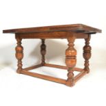 A large early 20th Century oak draw leaf refectory dining table raised on cup and cover supports