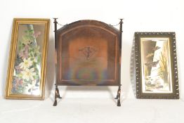 A mid 20th Century copper style fire screen with central applied decoration raised on scroll feet.