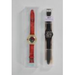 Two swatch wrist watches to include one on a black rubber strap with white roman numerals to the