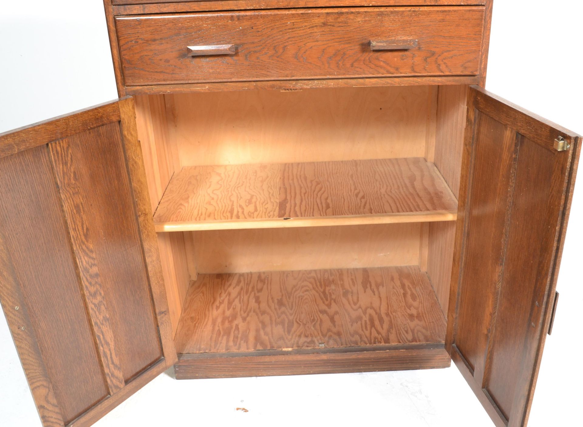 A mid century circa 1940's oak tallboy raised on a plinth base with twin cupboard and two drawers - Bild 5 aus 6