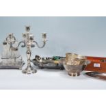 A collection of silver plated items to include a candelabra, cut glass cruet and stand, footed bowl,