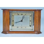 An Elliott of London mid century mahogany cased mantel clock of curved rectangular form having a