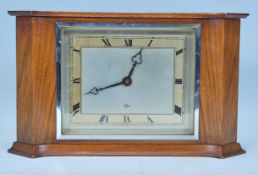 An Elliott of London mid century mahogany cased mantel clock of curved rectangular form having a