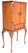 A mid century retro Queen Anne revival walnut cocktail cabinet on stand. The walnut double door