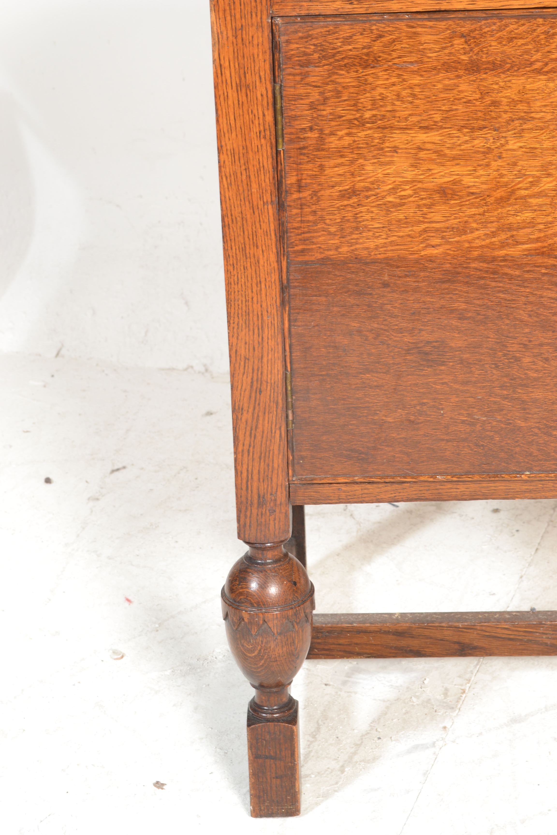 A 1930's oak sideboard being raised on cup and cover legs having twin cupboard doors under short - Image 3 of 6