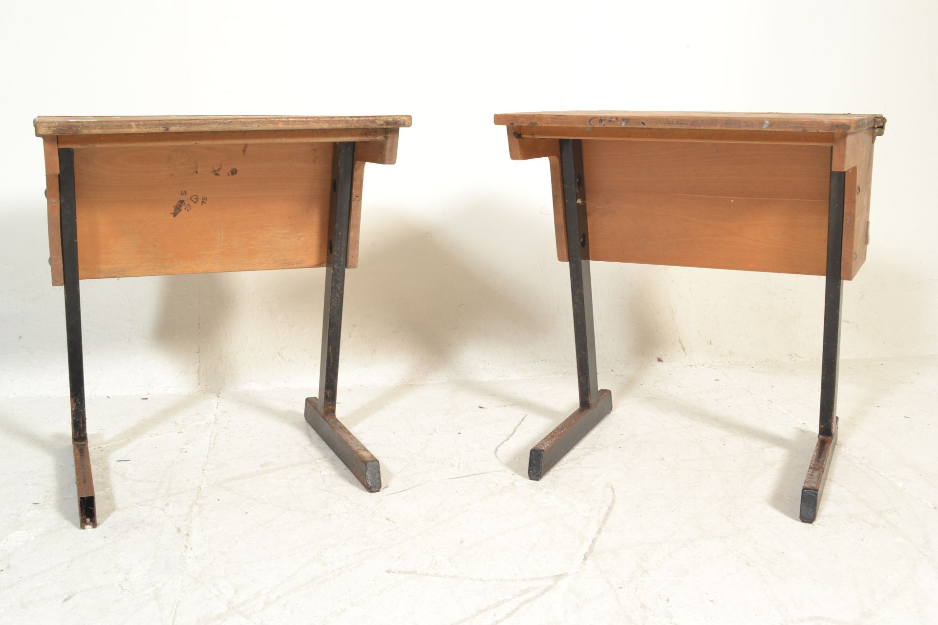 A pair of vintage mid 20th Century school desks, plank top with lift up flap to rear with storage