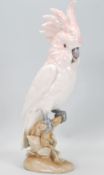 A 20th Century Royal Dux ceramic figurine in the form of a parrot / cockatoo having white and pink