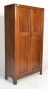 A 1930's oak single wardrobe raised on square legs having twin fielded panel doors enclosing a
