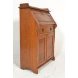 An early 20th Century Arts and crafts oak students bureau bookcase, gallery back with fall front