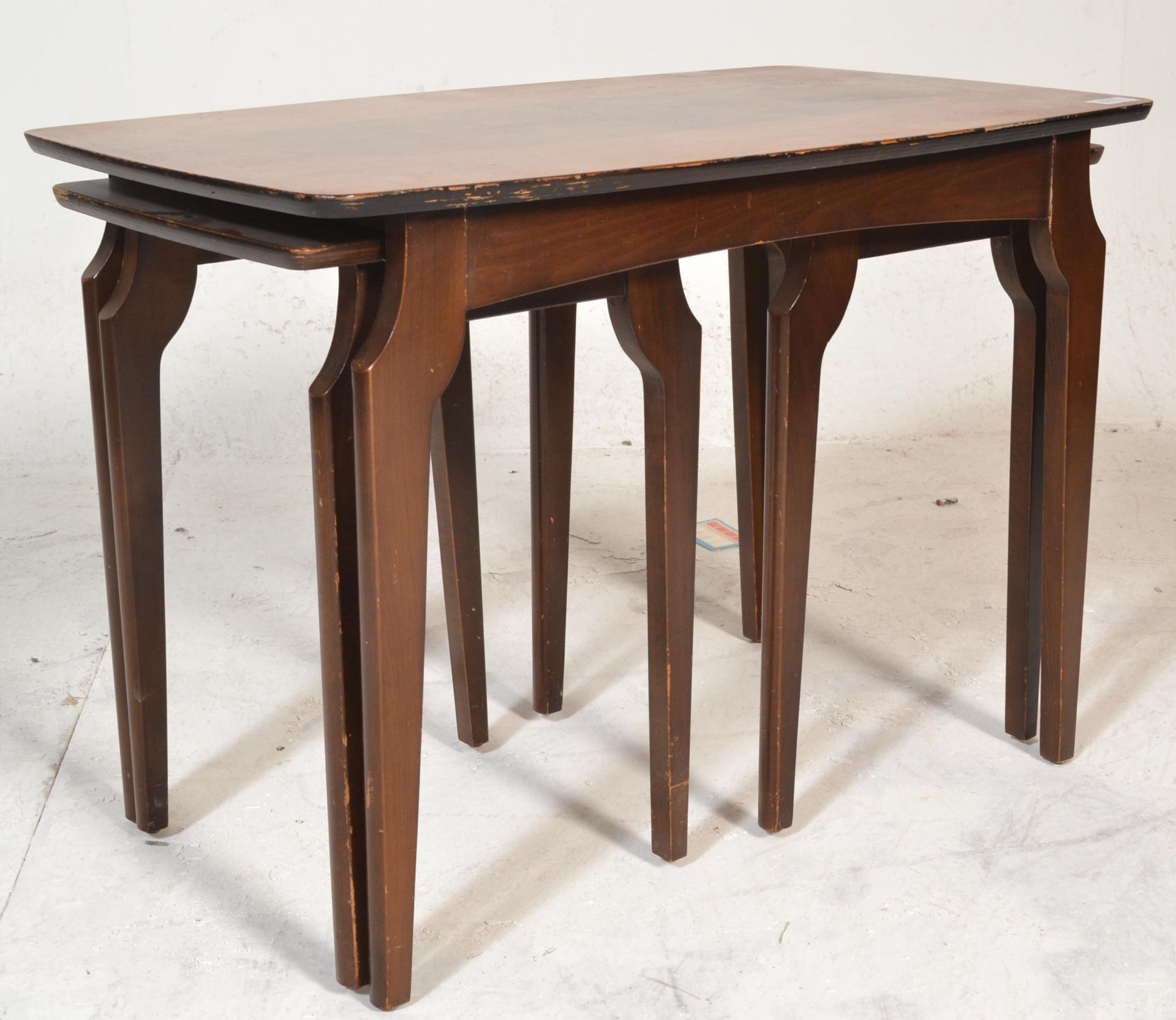 A mid century, circa 1950's teak wood and walnut inlaid graduating nest of tables. Raised on