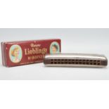 A vintage early 20th Century Unsere Lieblinge M. Hohner harmonica / mouth organ in original box.