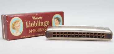 A vintage early 20th Century Unsere Lieblinge M. Hohner harmonica / mouth organ in original box.
