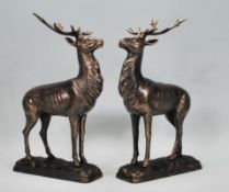 A pair of cast iron figurine ornaments in the form of two stags with a bronzed finish raised on