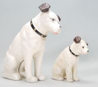 Two reproduction cast iron money banks in the form of HMV style terrier dogs being cold painted in