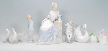 A selection of Lladro and Nao figurines to include a Nao Valencian girl with jug, three Lladro