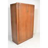 An early 20th Century Ernst Gomme for G Plan oak double wardrobe, two panel doors opening to