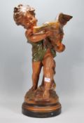 An early 20th Century 1920's antique chalkware 'Girl and Duck' painted figurine raised on a pedestal