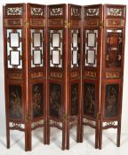 A large 20th Century six fold Chinese lacquered pine screen having scroll fret work panel atop