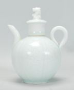 An early 20th Century Chinese teapot of small proportions finished in a light green glaze having