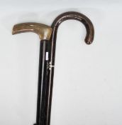 A pair of 20th Century walking sticks to include a an ebonised shaft having a crook horn handle, a