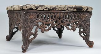 An antique style cast iron upholstered foot stool in the manner of Coalbrookdale. The cast base with