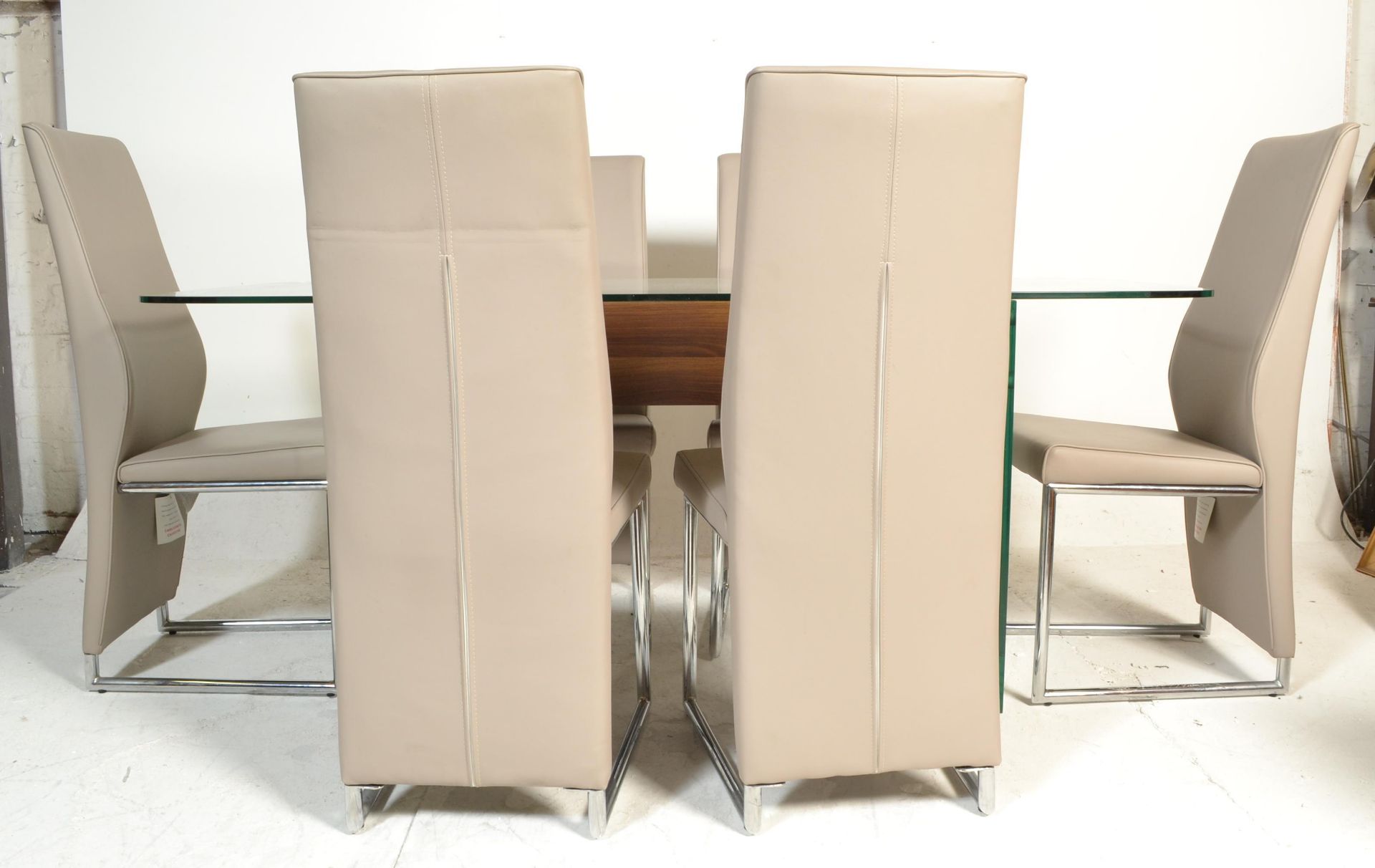 A contemporary large designer modernist glass dining table. Raised on glass panel uprights with