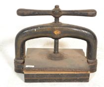 A 19th century Victorian heavy ebonised cast iron book press with screw handle, the underside