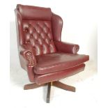 A vintage 20th Century Chesterfield style leather button back / wingback swivel armchair raised on