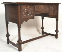 A Queen Anne revival carved oak writing table desk being raised on stile feet with cup and cover
