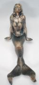 A cast iron figurine / ornament in the form of a reclining mermaid having a gilt and turquoise