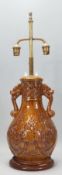 A vintage 20th Century Chinese converted lamp finished in a brown glaze having two dragons chasing a